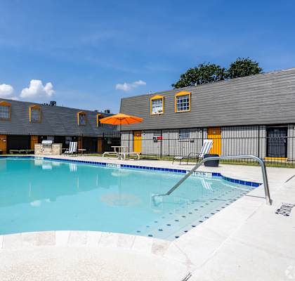 A large outdoor swimming pool with a sun lounger. at La Bella Apartments, Fort Worth, TX, 76116