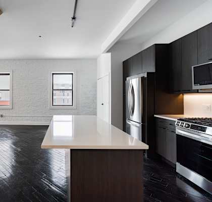 A kitchen with a white countertop and black cabinets.