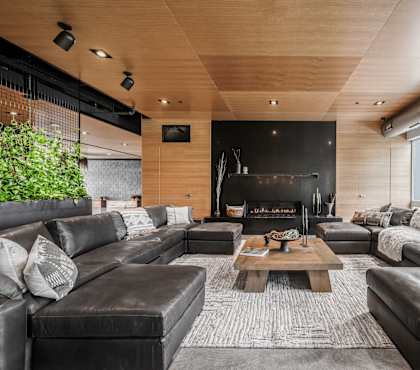 A modern living room with a fireplace and leather furniture.