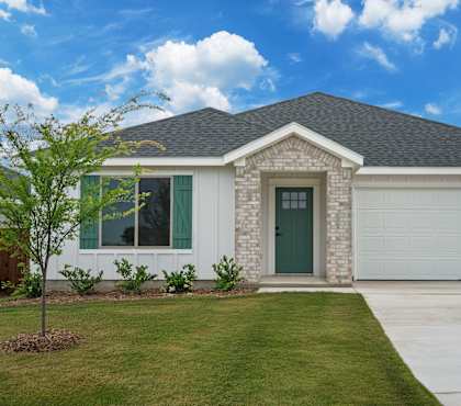 A house with a green door and a grey garage door.