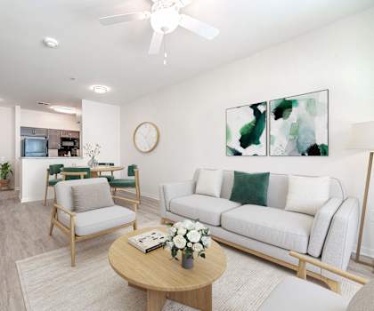 A living room with a white couch, a wooden coffee table, and a ceiling fan.