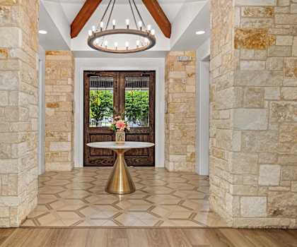 the entryway of a house with stone walls and a table