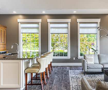 A well-lit, modern kitchen with a bar area and a couch.
