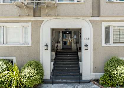 the front of a building with stairs and a door