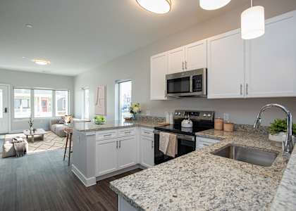 A kitchen with granite countertops and white cabinets.