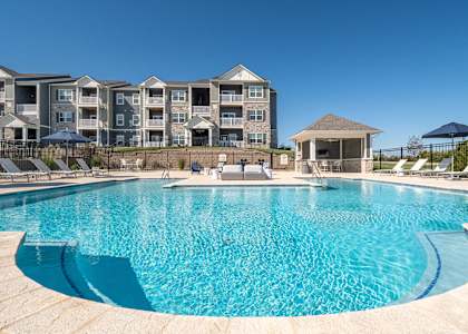 A large swimming pool in front of apartment buildings.