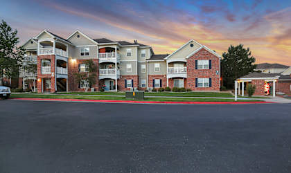 A row of apartment buildings with a car parked in front.