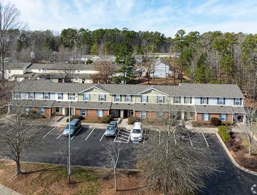 an aerial view of a building with cars parked in a parking lot at Pendleton Townhomes Apartments, Durham, NC