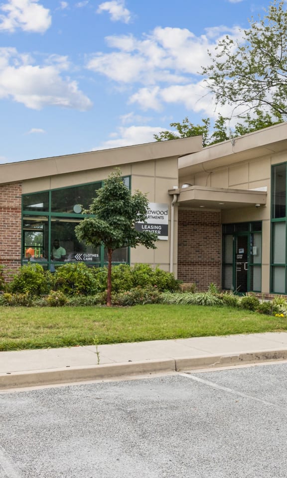 the front of a building with a sidewalk and grass