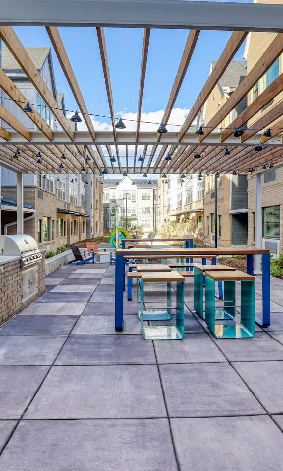 A long covered walkway with benches and a brick wall on one side.