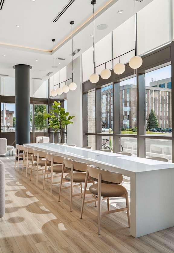 the lobby of a building with a long bar and chairs