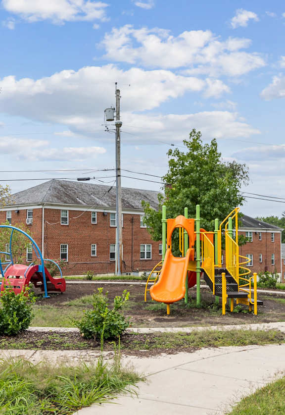 a playground in a park in front of a brick building