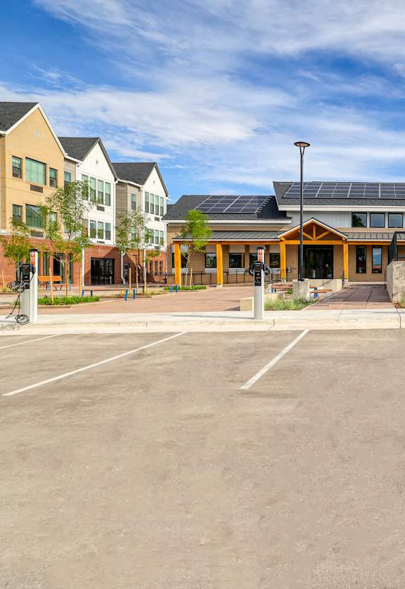 A parking lot with a building and a bicycle in the background.