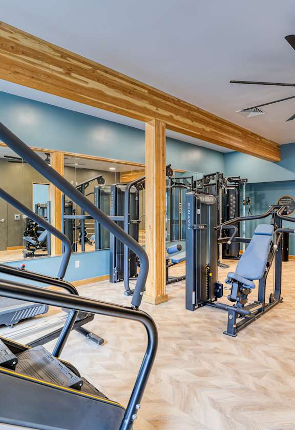 A gym with treadmills, weights, and a mirror.