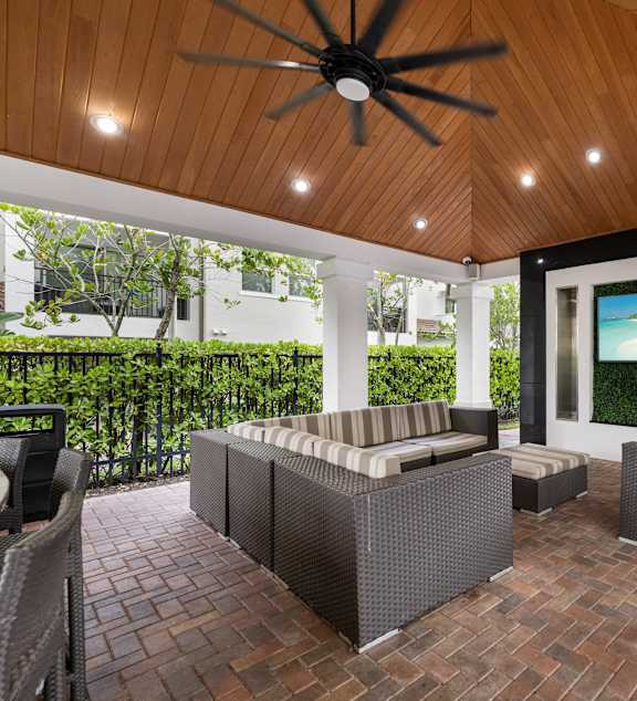 A patio with a ceiling fan and a couch.
