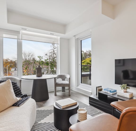 a living room and kitchen with a couch and two stools