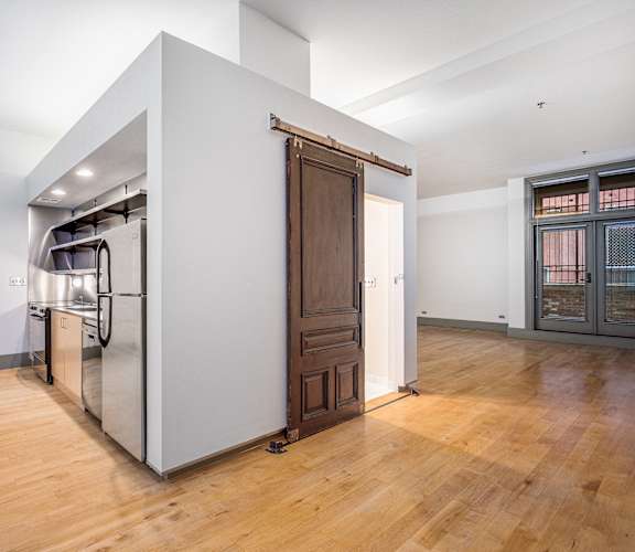 a large kitchen with a stainless steel refrigerator and a wooden door