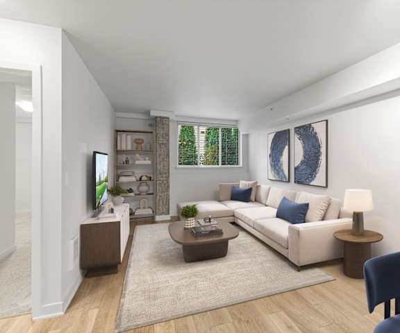 A living room with a white couch, a coffee table, and a blue chair.