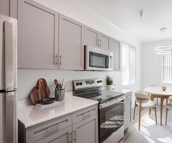 A modern kitchen with a refrigerator, oven, and microwave.
