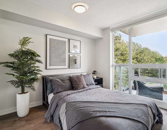 a bedroom with a large window and a plant