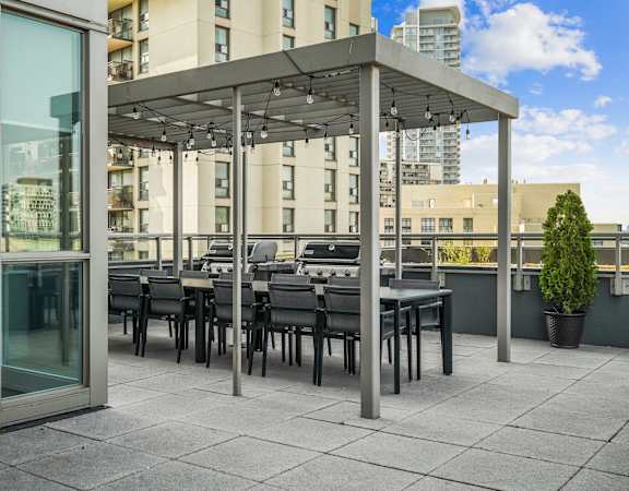 a communal terrace with tables and chairs under a canopy