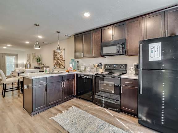 Kitchen with cherry wood cabinets and black appliances at Forest Hills Racquet Club, Augusta