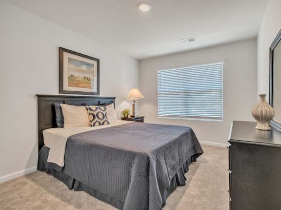 a bedroom with a bed and a dresser and a window