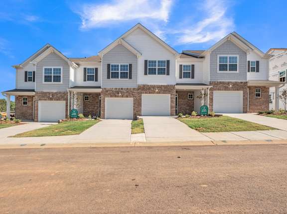 a large house with two garage doors on a sidewalk