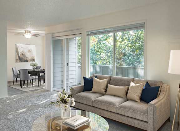 A living room with a grey couch, a coffee table, and a painting on the wall.