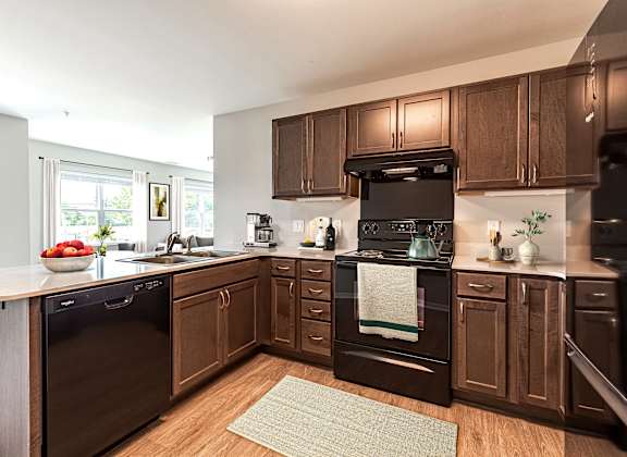 A kitchen with dark wood cabinets and appliances.