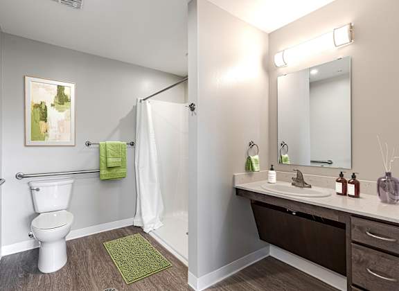 A bathroom with a toilet, sink, and mirror.
