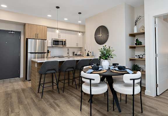A modern kitchen with a dining table set for four.at The Fifth at Palisades, Edmonton, AB, T6V 0N5