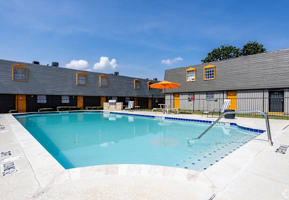 A large outdoor swimming pool with a sun lounger. at La Bella Apartments, Fort Worth, TX, 76116