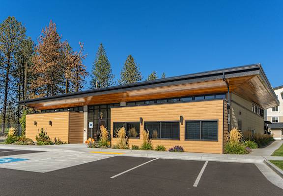 A modern building with a parking lot in front.
