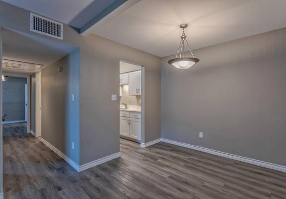 A room with a wooden floor and a hanging light fixture.