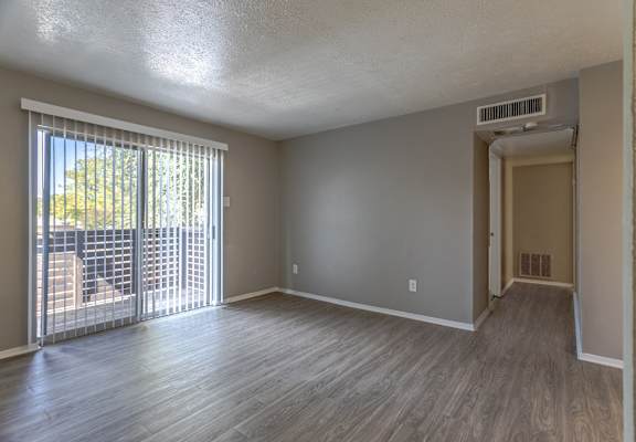 A room with a sliding glass door leading to a balcony.