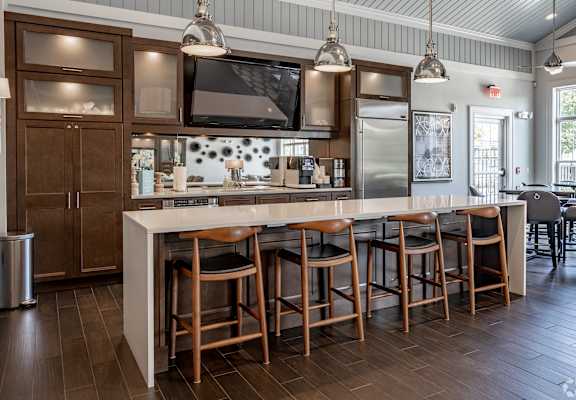 A kitchen with a bar area and wooden floors.