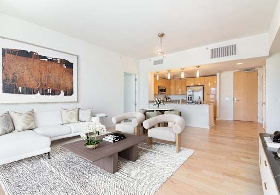 A living room with a white couch and a brown coffee table at The Grand Apartments, Oakland, CA, 94612