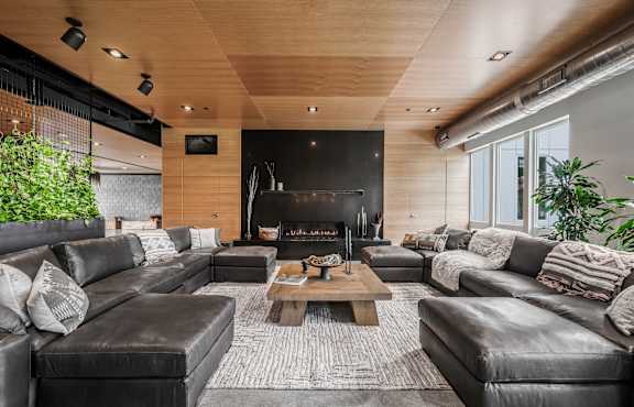 A modern living room with a fireplace and leather furniture.