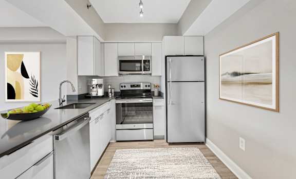 a modern kitchen with stainless steel appliances and white cabinets