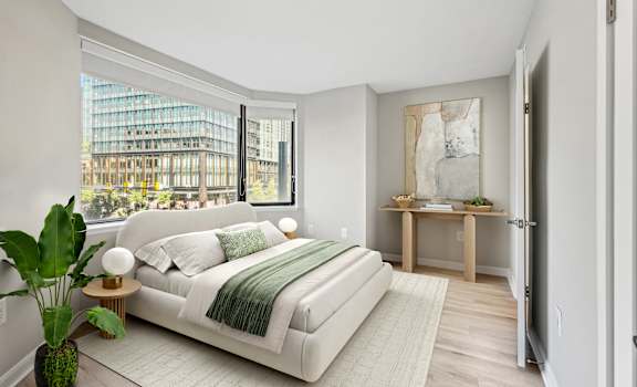 a bedroom with a white bed and a large window