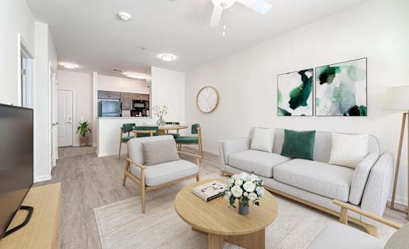 A living room with a white couch, a wooden coffee table, and a ceiling fan.