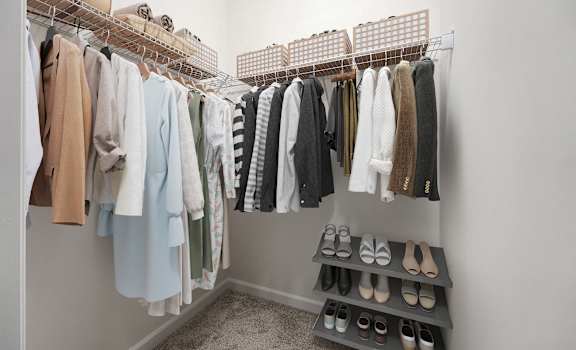 A closet with clothes and shoes.