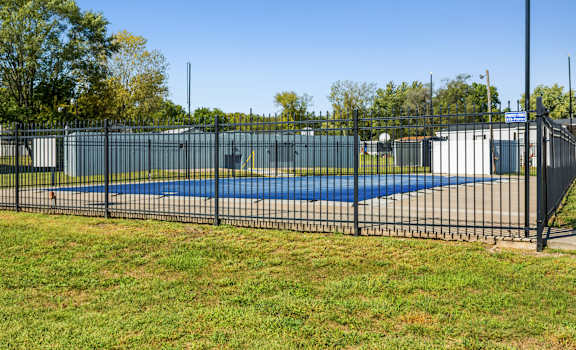 A black fence surrounds a blue pool.
