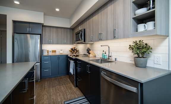 a kitchen with dark cabinets and a stainless steel refrigerator