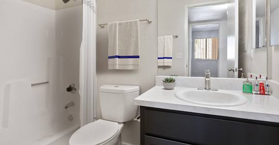 A white toilet sits next to a white sink in a bathroom.