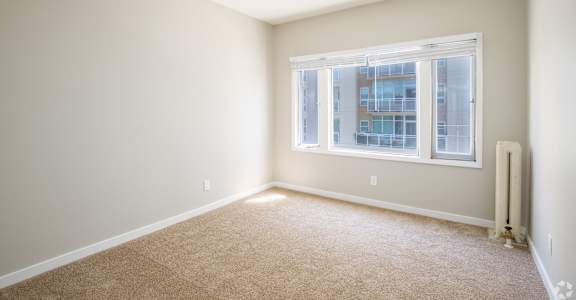 an empty room with carpet and a window