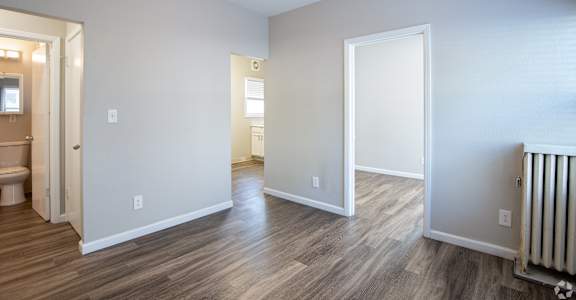 an empty living room with wood floors and a ceiling fan