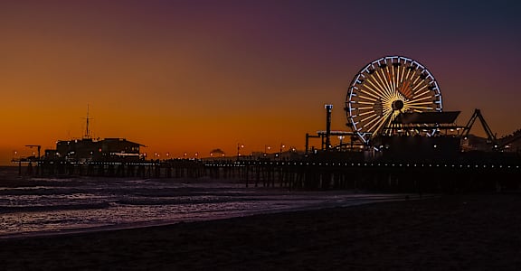 a ferris wheel on the beach at sunset