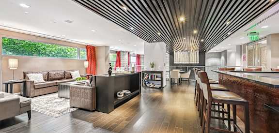 the lobby of a hotel with a living room and a dining room